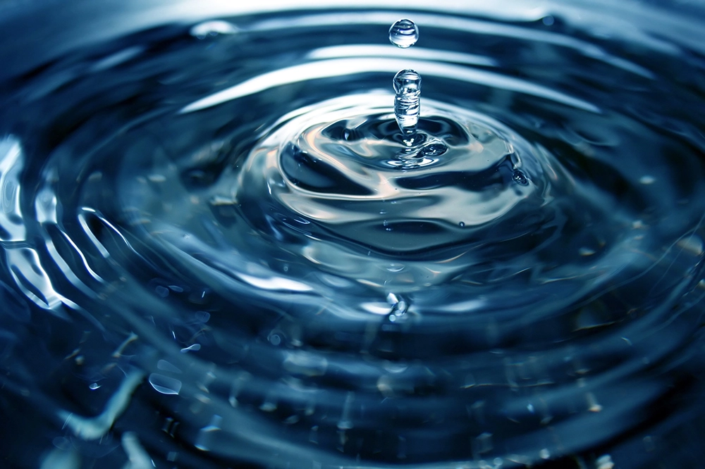 Symbolbild Trinkwasseraufbereitung. Tropfen trifft Wasseroberfläche.